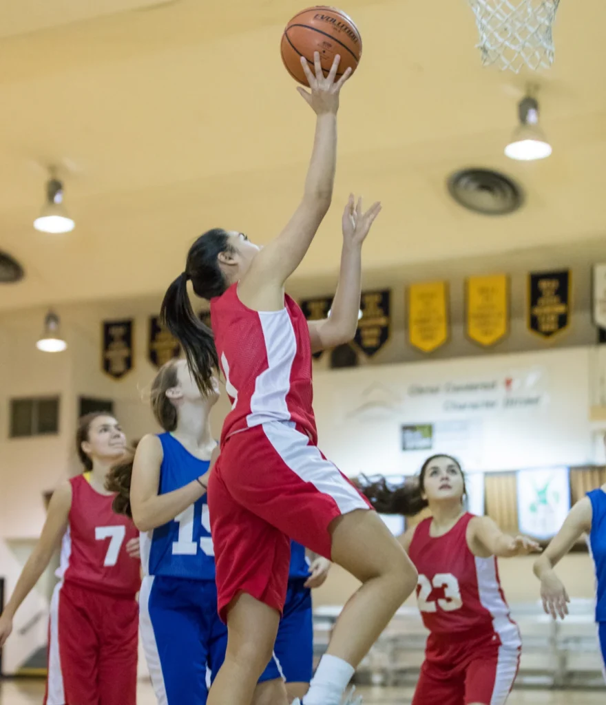 Women playing basketball in a gym